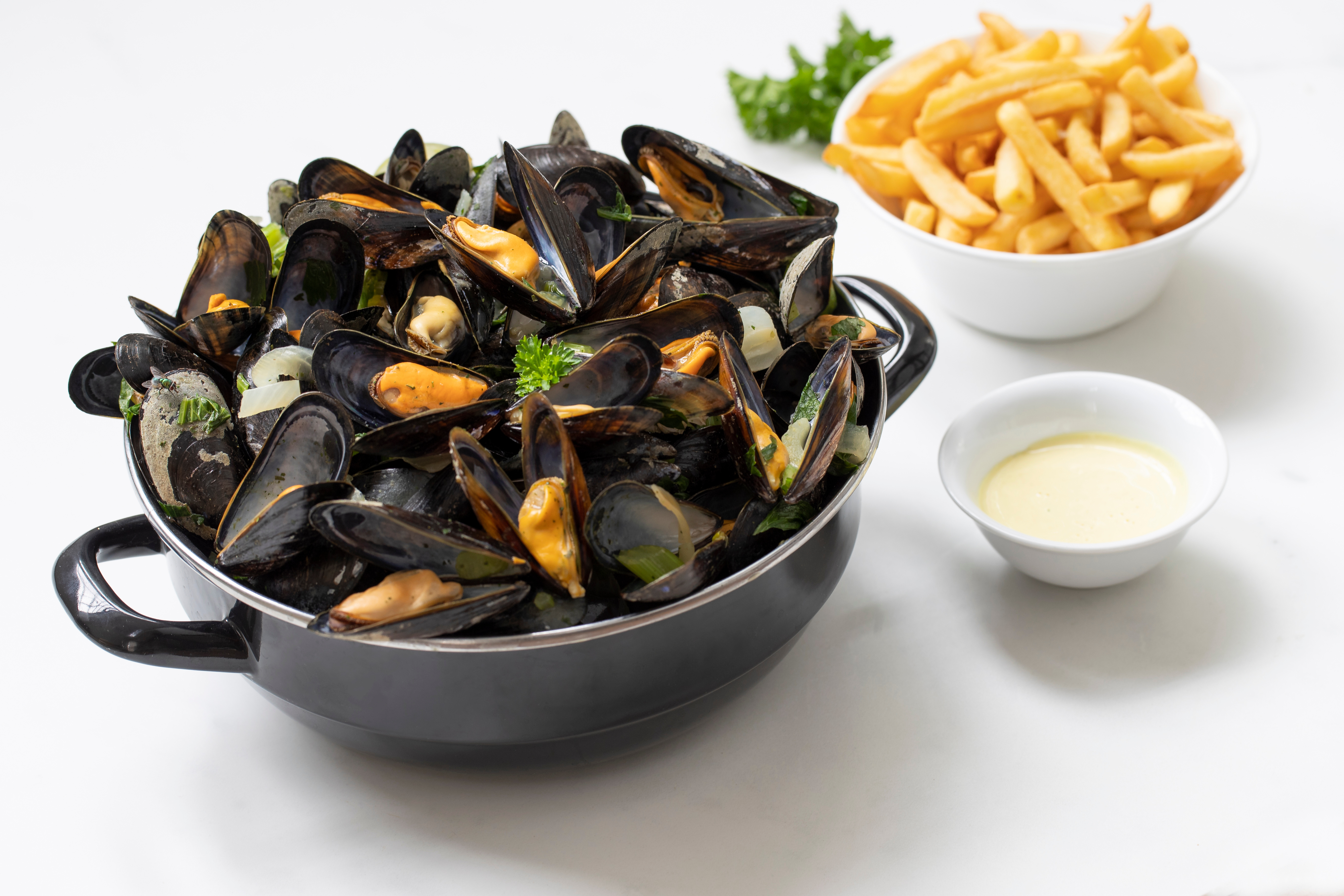 gekochte Miesmuscheln im Topf, dazu Pommes und Sauce