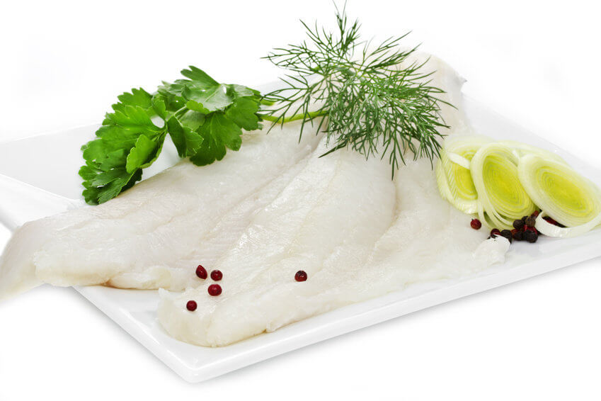 Rohes Seelachsfilet mit Kräutern und Lauch auf Teller