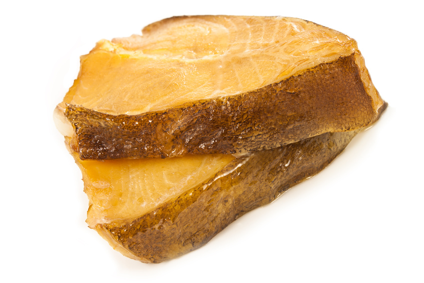 Geräuchertes Fischfilet auf weißem Hintergrund Nahaufnahme eines geräucherten Fischfilets mit goldener Kruste und saftigem Innenleben auf weißem Hintergrund