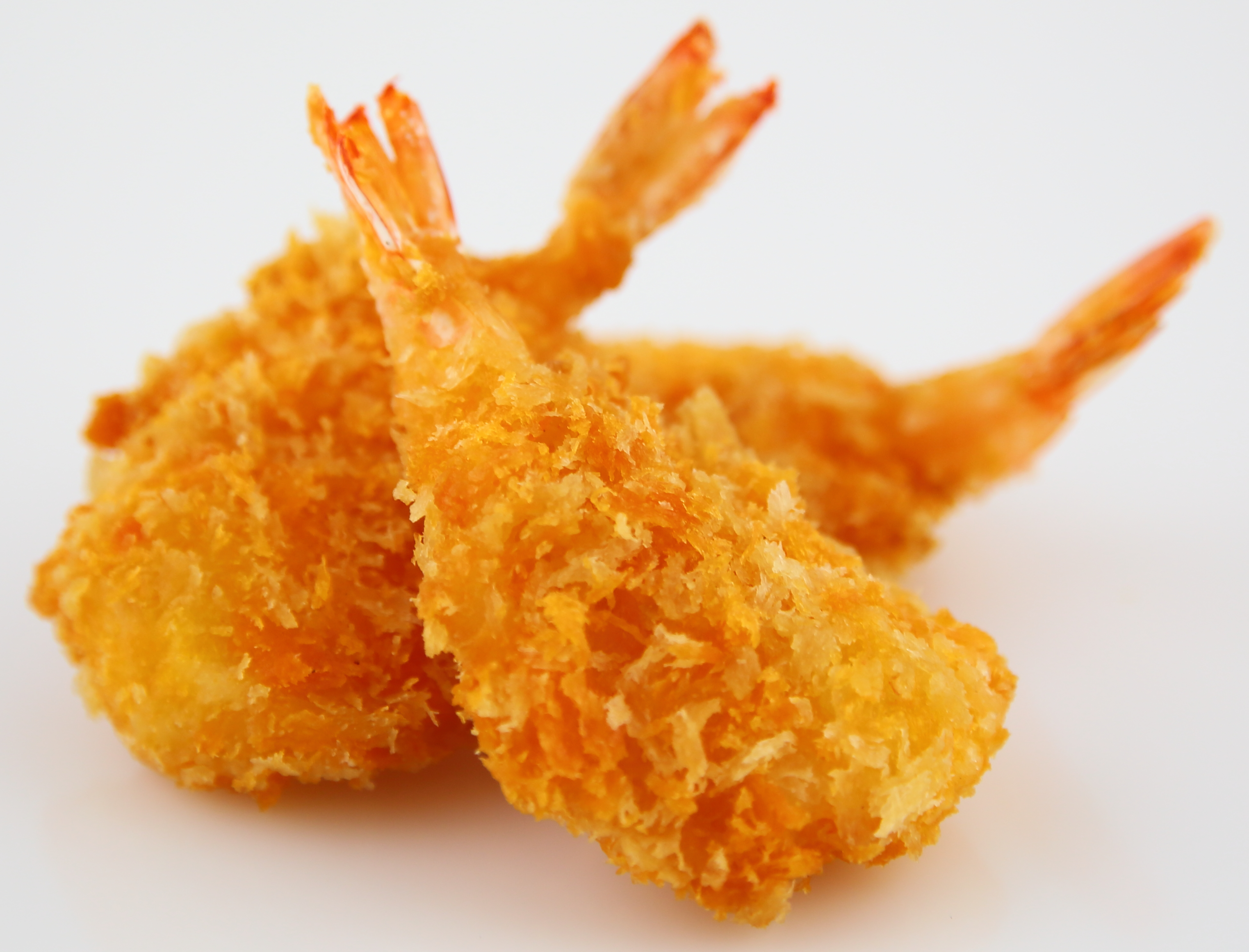 Knusprige panierte Garnelen perfekt für Vorspeisen Drei goldbraun frittierte, panierte Garnelen auf weißem Hintergrund