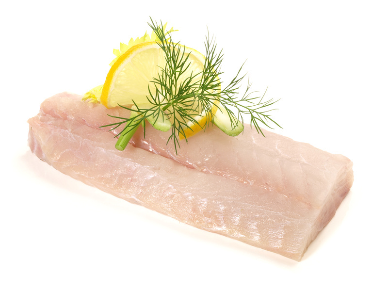 Frisches Fischfilet mit Zitrone und Dill garniert Fischfilet auf weißem Hintergrund, dekoriert mit Zitronenscheibe und Dill